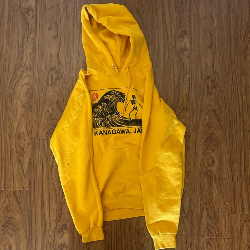 A mustard yellow sweatshirt with the words Kanazawa Japan.